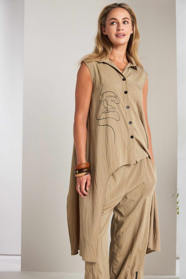 Woman wearing a ta sleeveless top and trouser set against a plain background