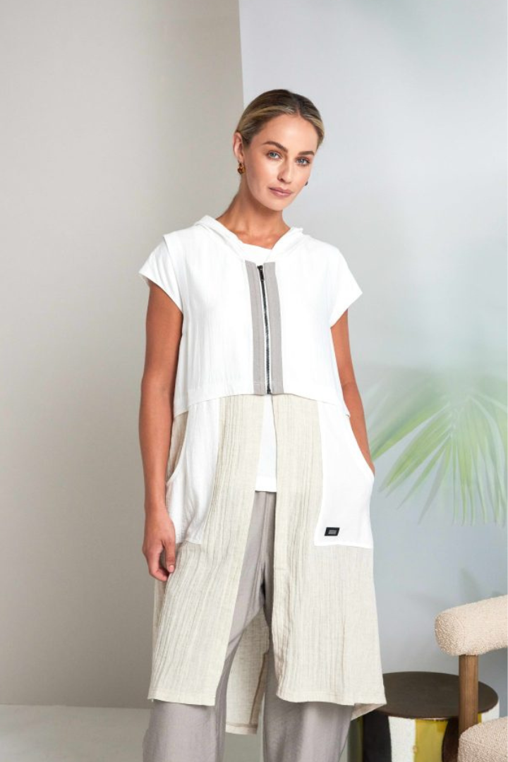 Woman wearing a white and pebble long waistcoat against a light background